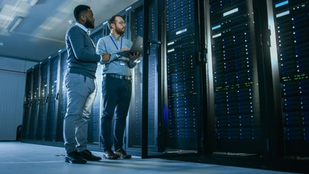 Image of two men standing infront of data center