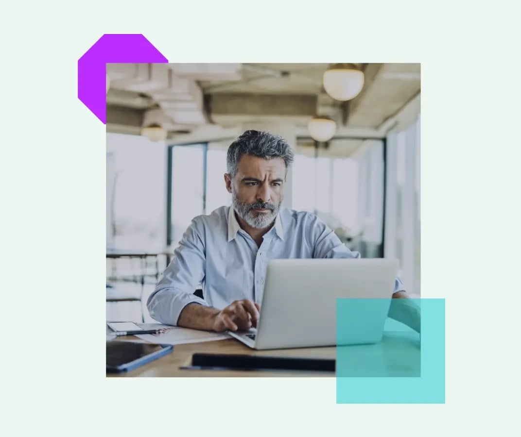 Image of a person working on a laptop in an office, surrounded by purple and teal geometric design elements