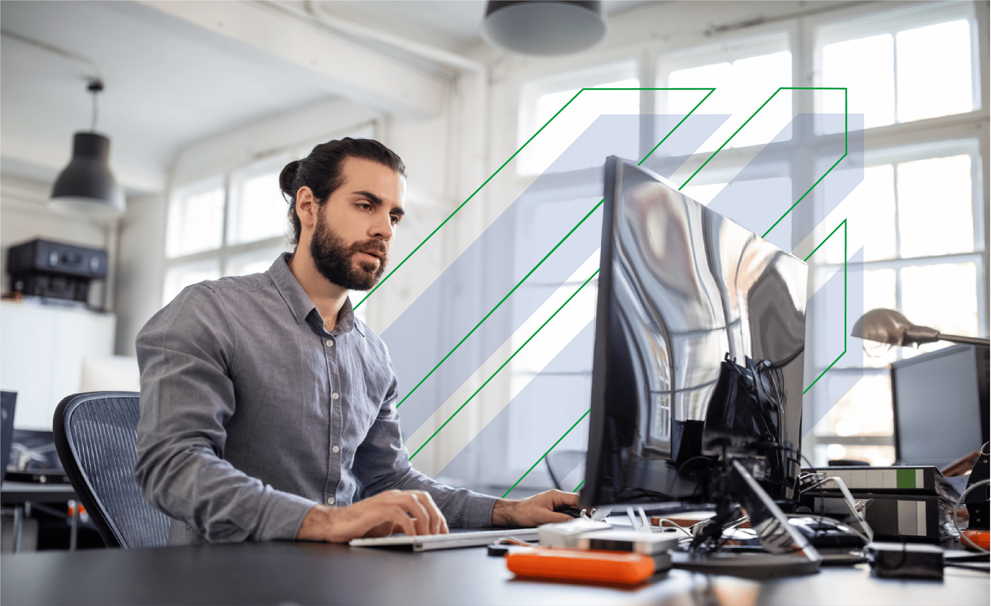 Man in business attire working at his desk whilst using computer.