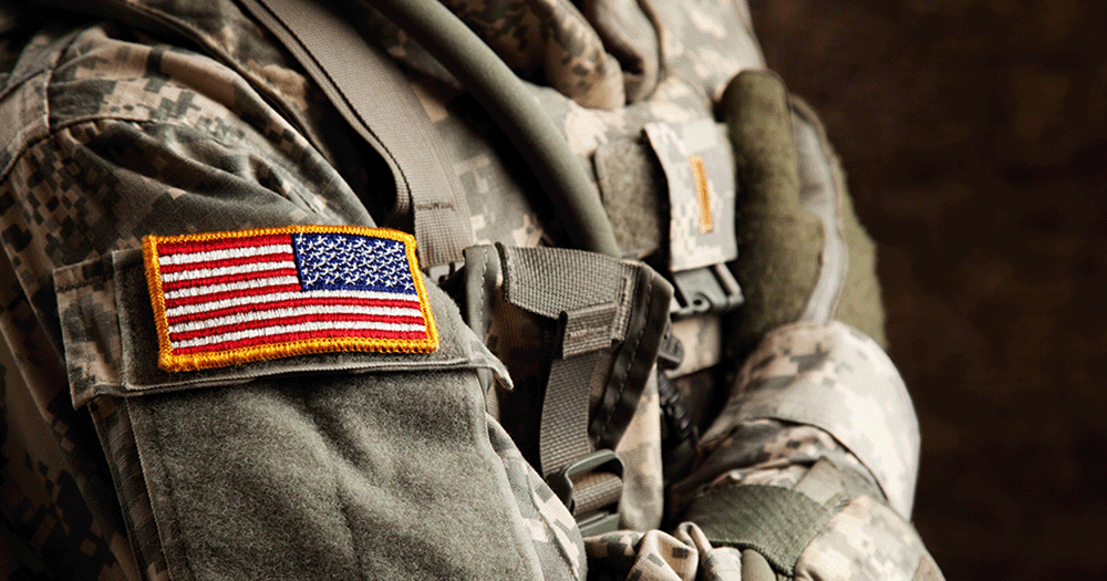 Close up of military jacket, showing us US flag stitched on sleeve.