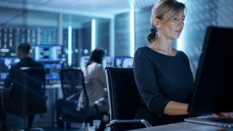 Image of woman looking at computer screen in office