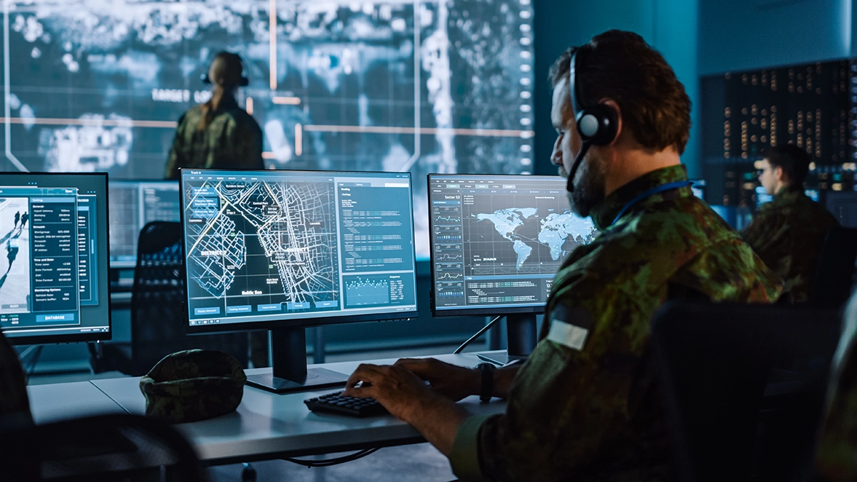 Military Surveillance Officer watching city tracking operation on pc, in an office for cyber control and monitoring for National Security, Technology and Army Communications.