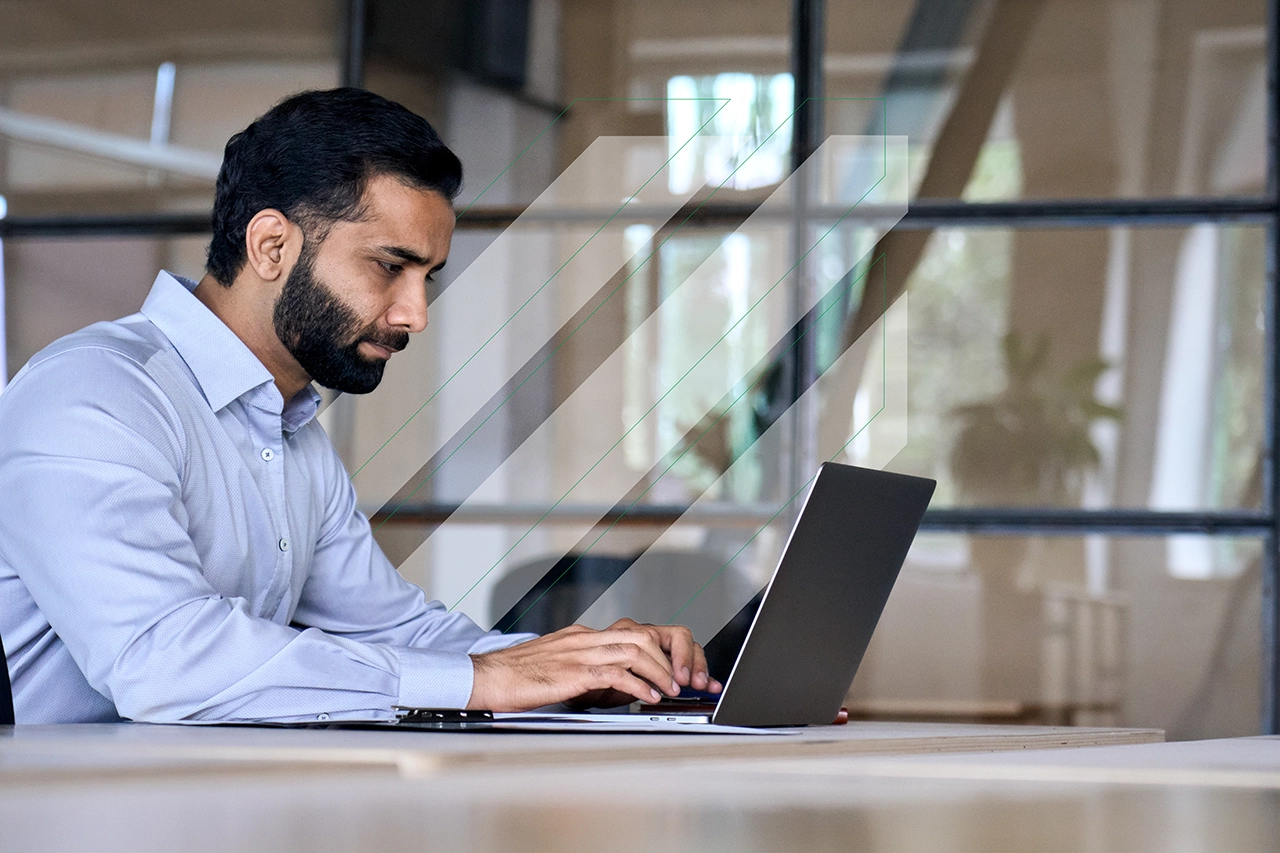 A man sitting at a laptop in an office