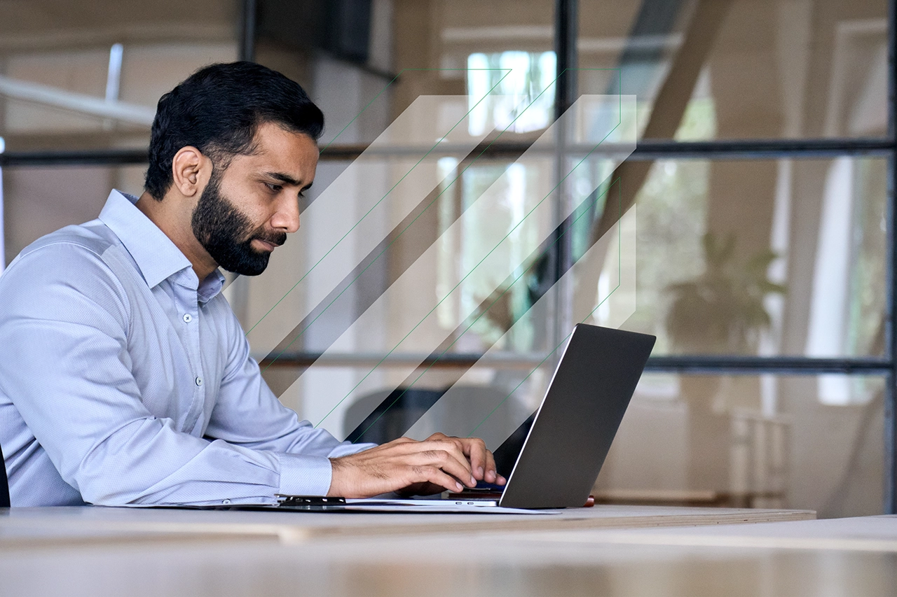 A man sitting at a laptop in an office.